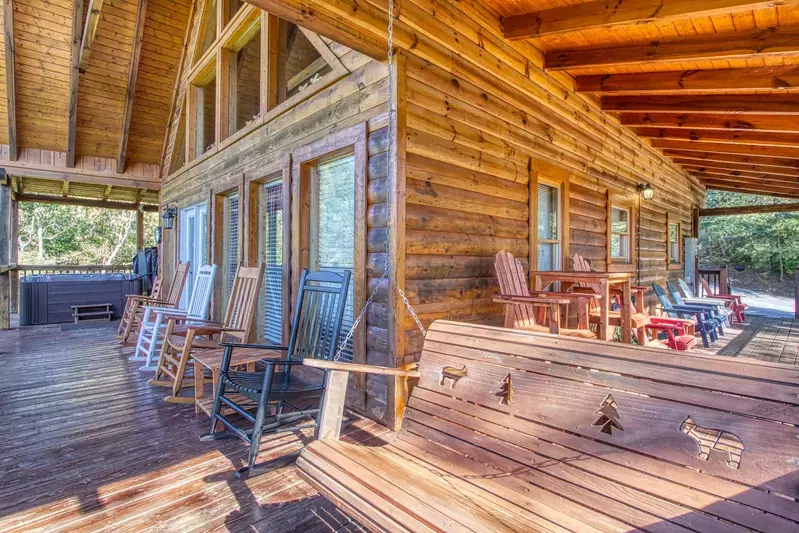 rocking chairs, porch swing, and hot tub on covered deck of Lazy Moose Retreat