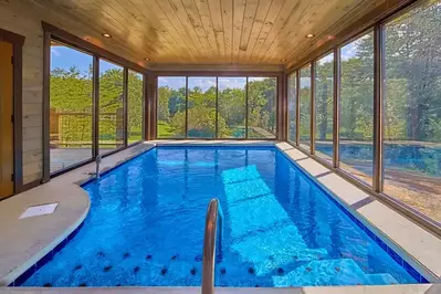 private indoor pool surrounded by wooded views at Smoky Mountain Springs luxury cabin in Pigeon Forge